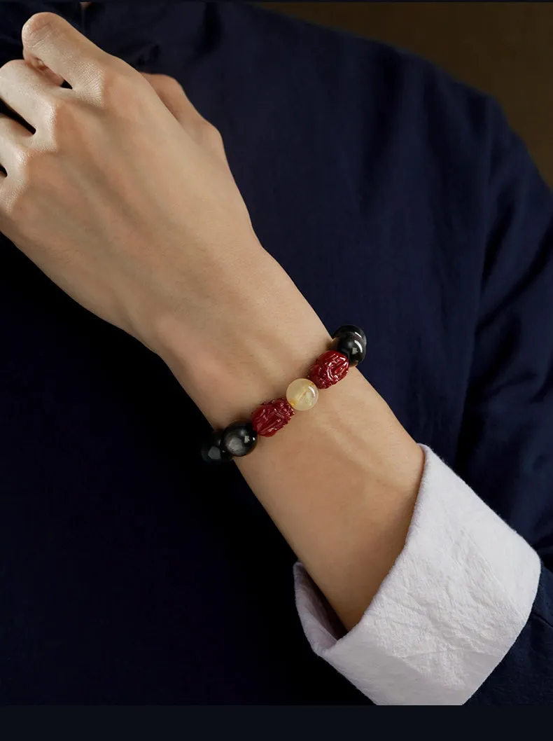 Carved cinnabar beads bracelet with gold obsidian animal zodiac design on a gift box.