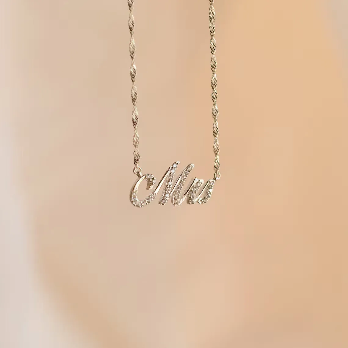 Customised copper geometric name necklace for women in gold finish on white background