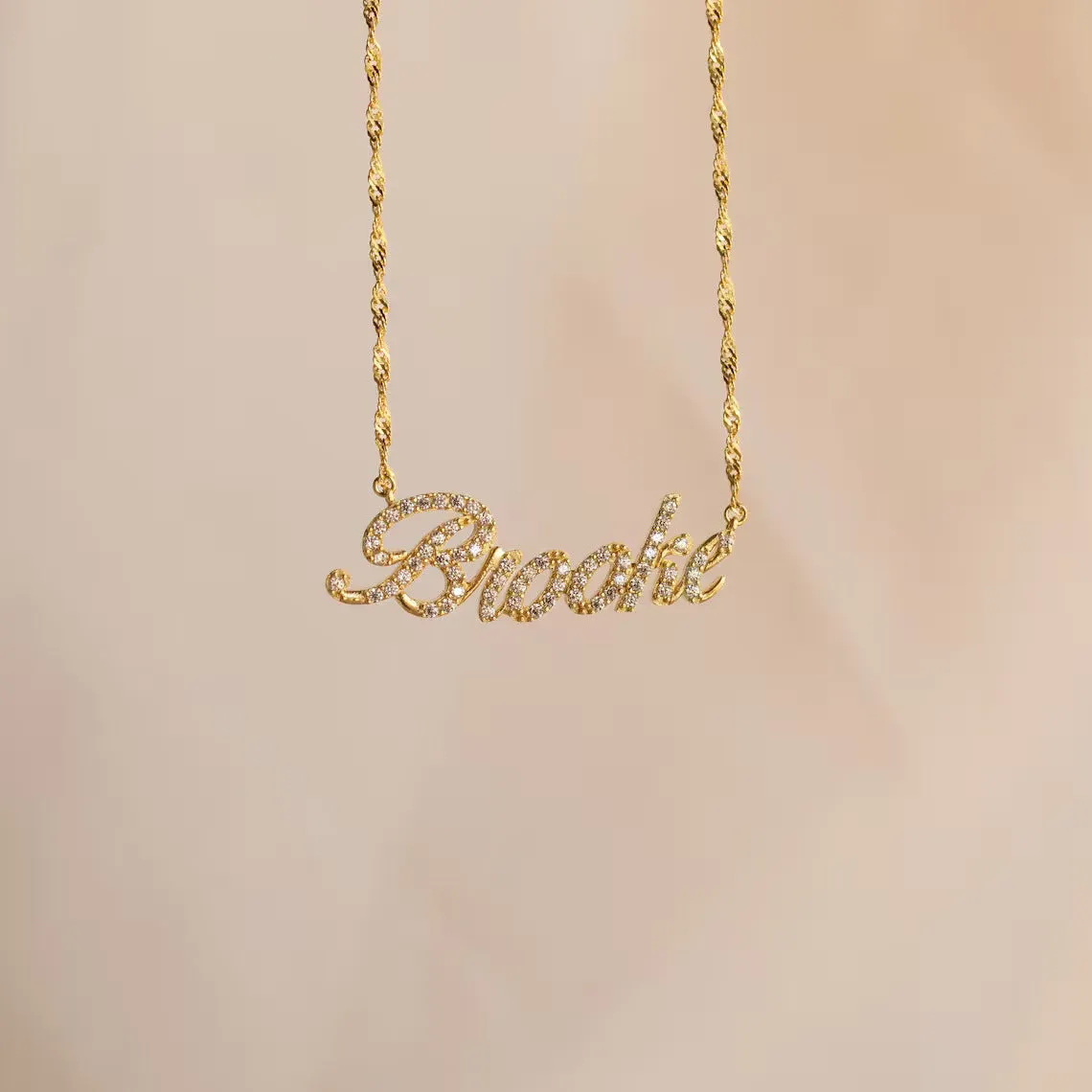Customised copper geometric name necklace for women in gold finish on white background