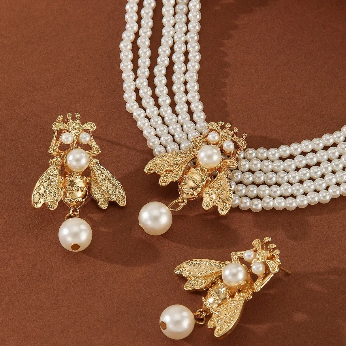 Golden bee earrings and necklace set on display with alloy pendant and regular chain