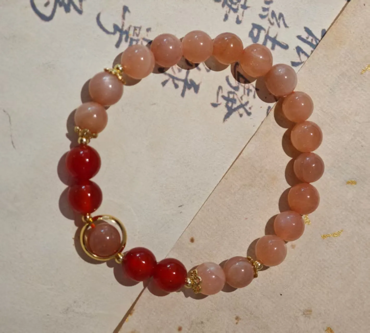 Handmade red agate and sunstone bracelet with carved xiangyun ethnic motifs, 8mm bead diameter