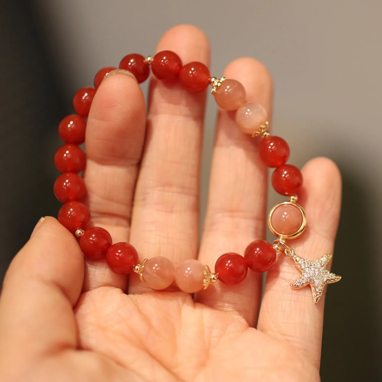 Handmade red agate and sunstone bracelet with carved xiangyun ethnic motifs, 8mm bead diameter