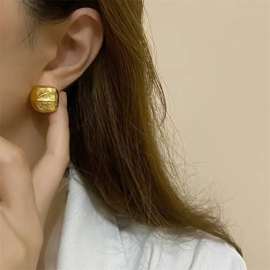 Minimalist metal alloy stud earrings with a simple circle design on a white background.