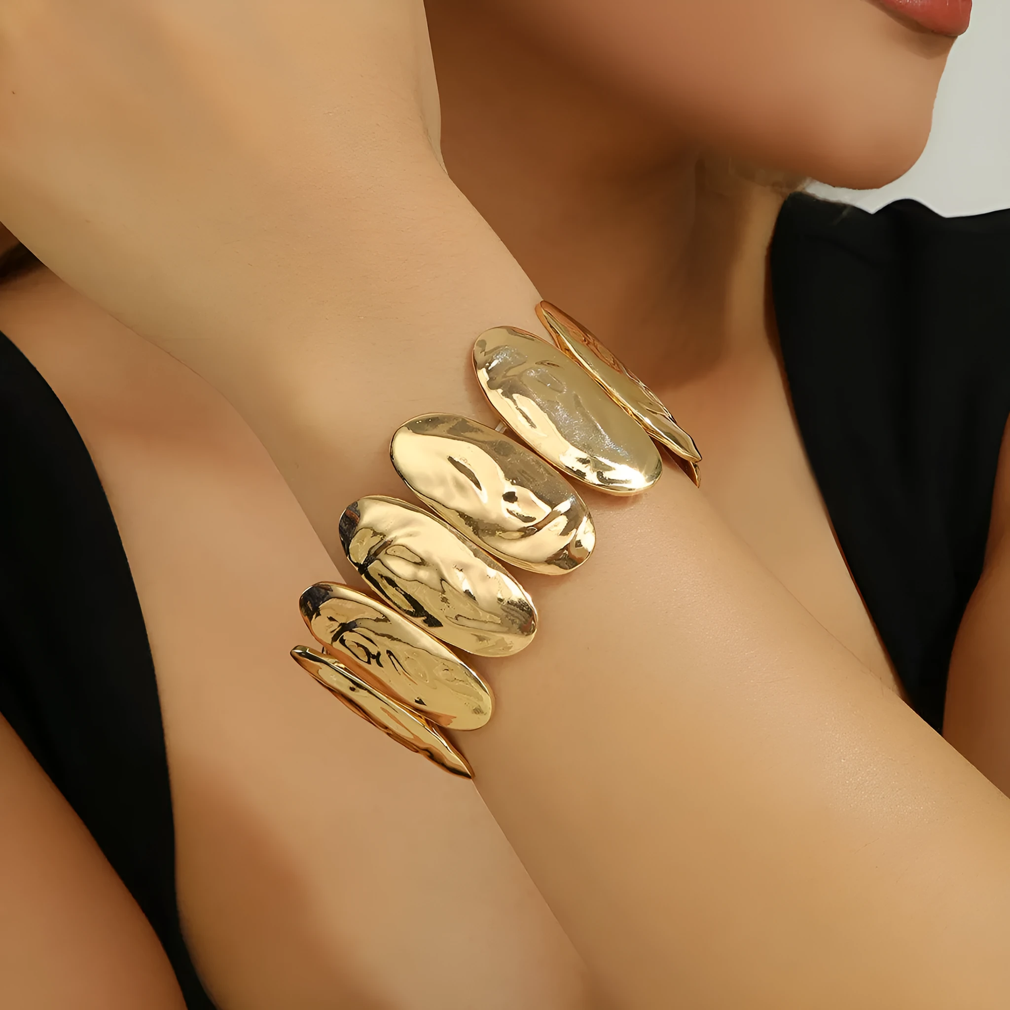 Gold exaggerated elliptical cuff bangle with 4mm band width on a neutral background