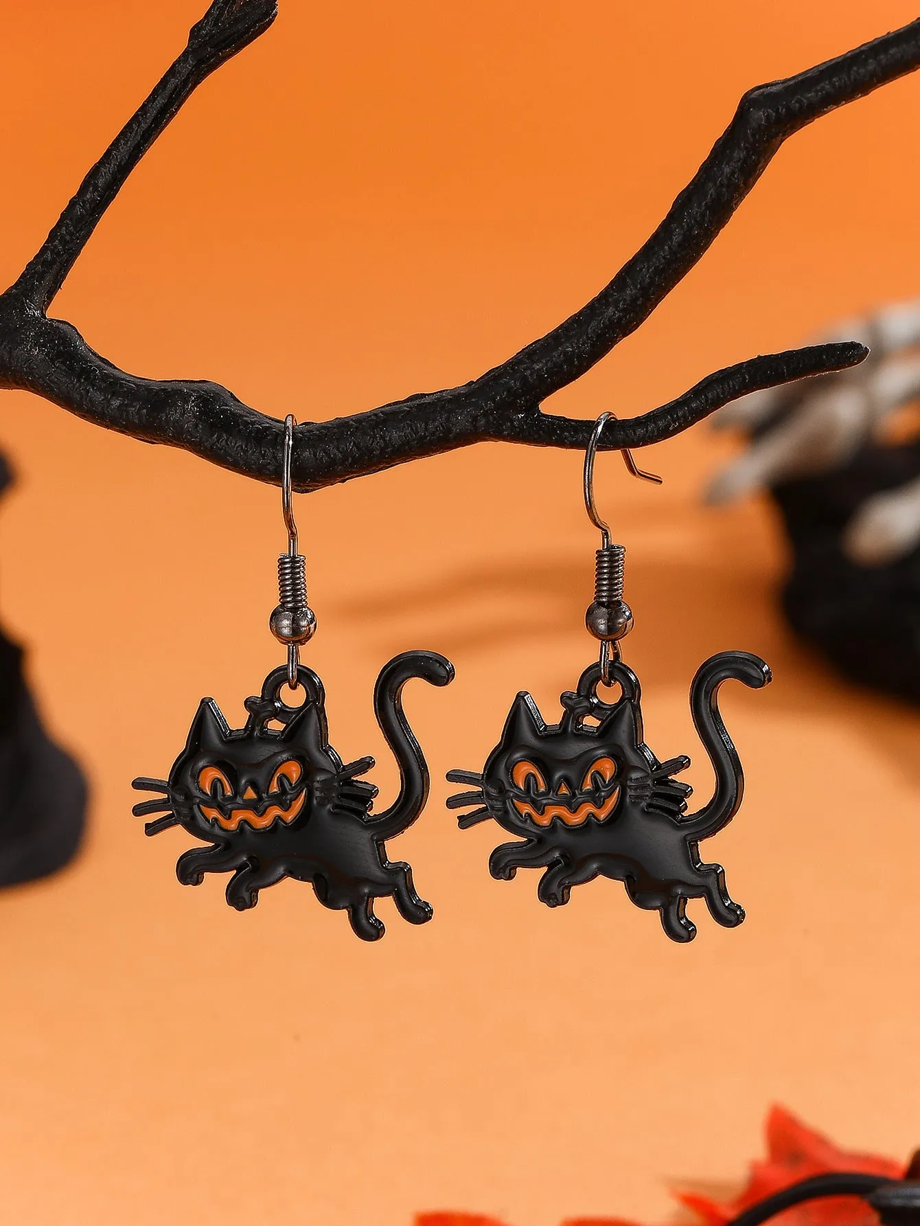 Set of six Halloween earrings with bat, cat, pumpkin head, skeleton, spider, and witch motifs on a dark background
