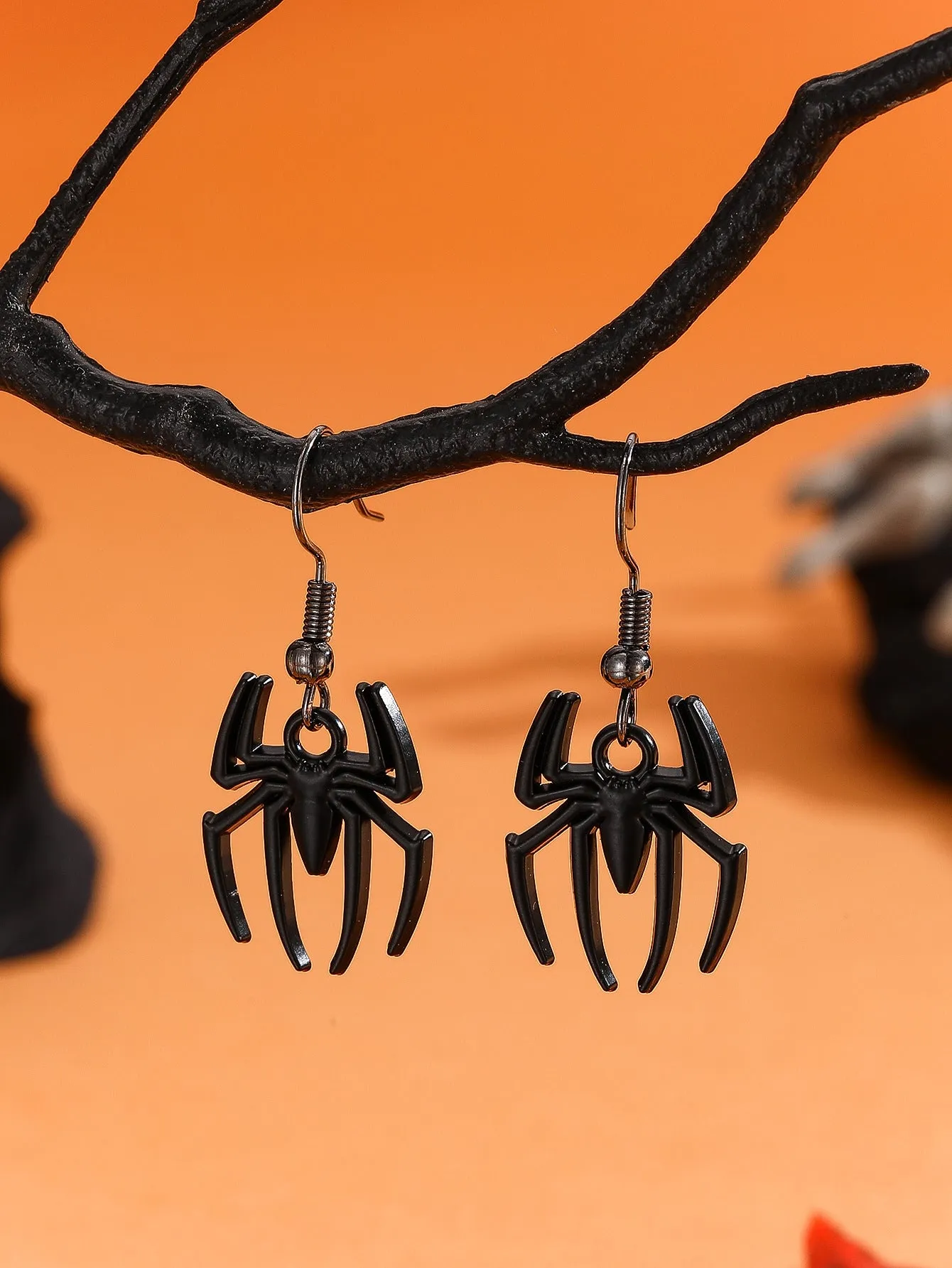 Set of six Halloween earrings with bat, cat, pumpkin head, skeleton, spider, and witch motifs on a dark background