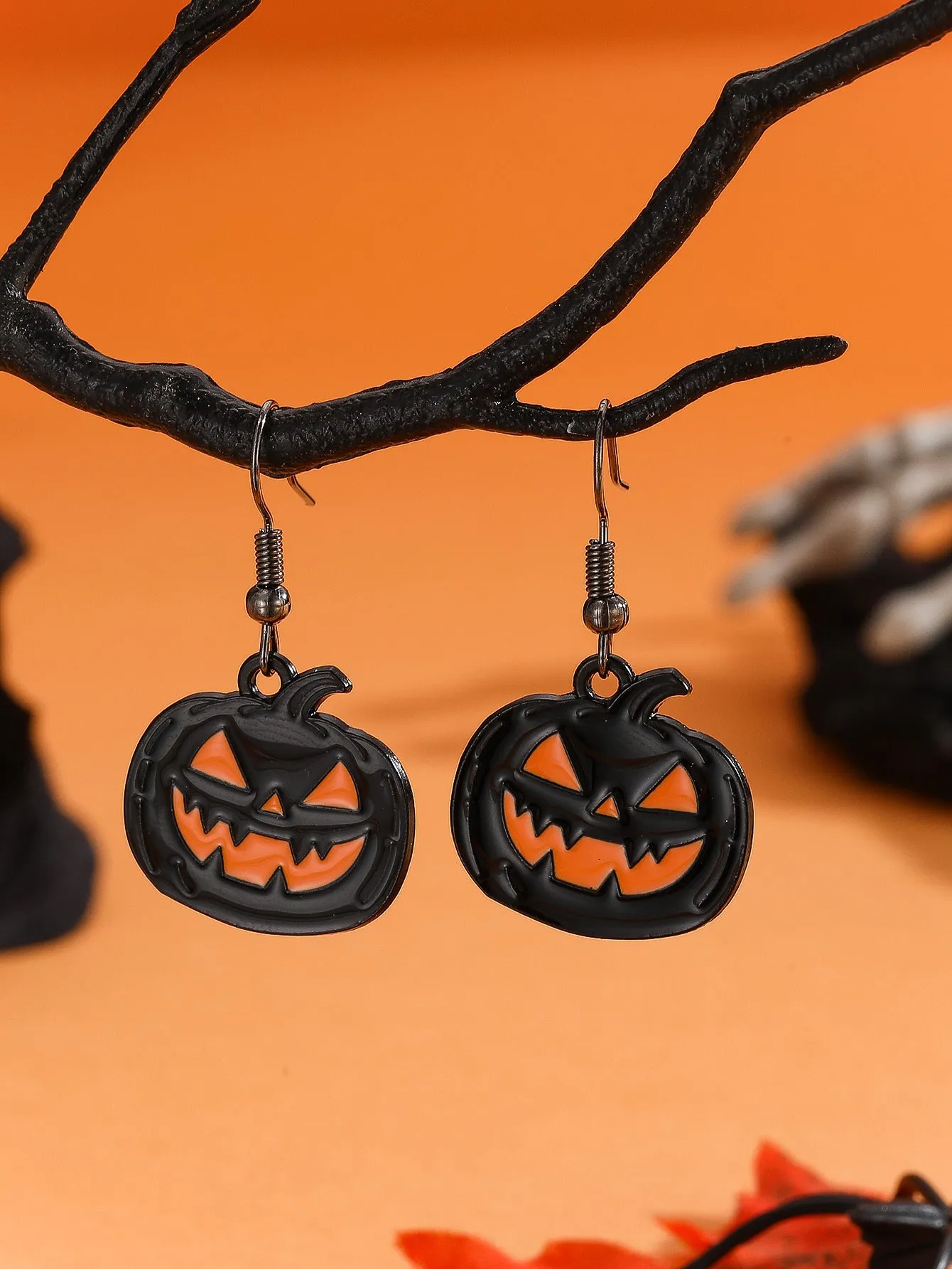 Set of six Halloween earrings with bat, cat, pumpkin head, skeleton, spider, and witch motifs on a dark background