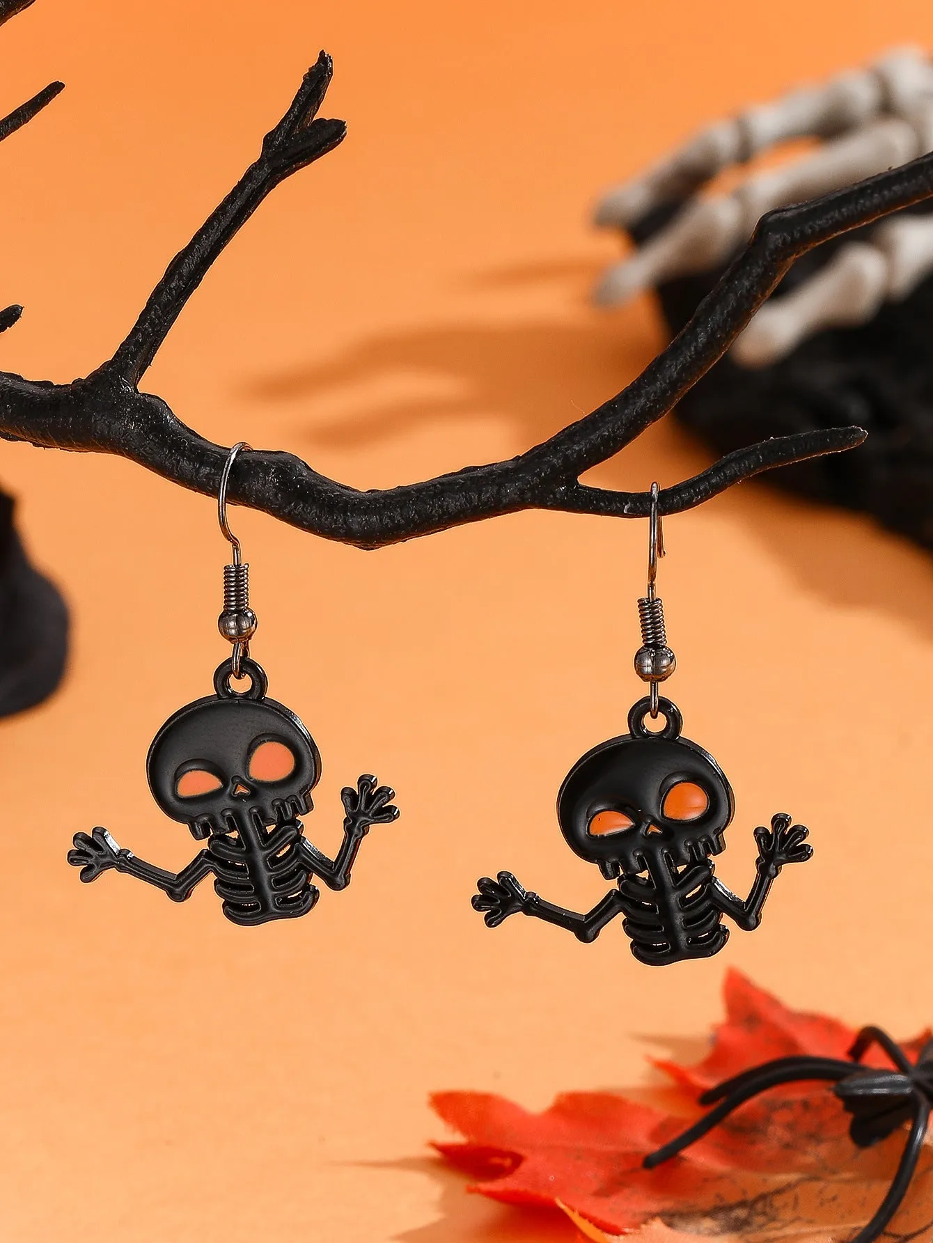 Set of six Halloween earrings with bat, cat, pumpkin head, skeleton, spider, and witch motifs on a dark background
