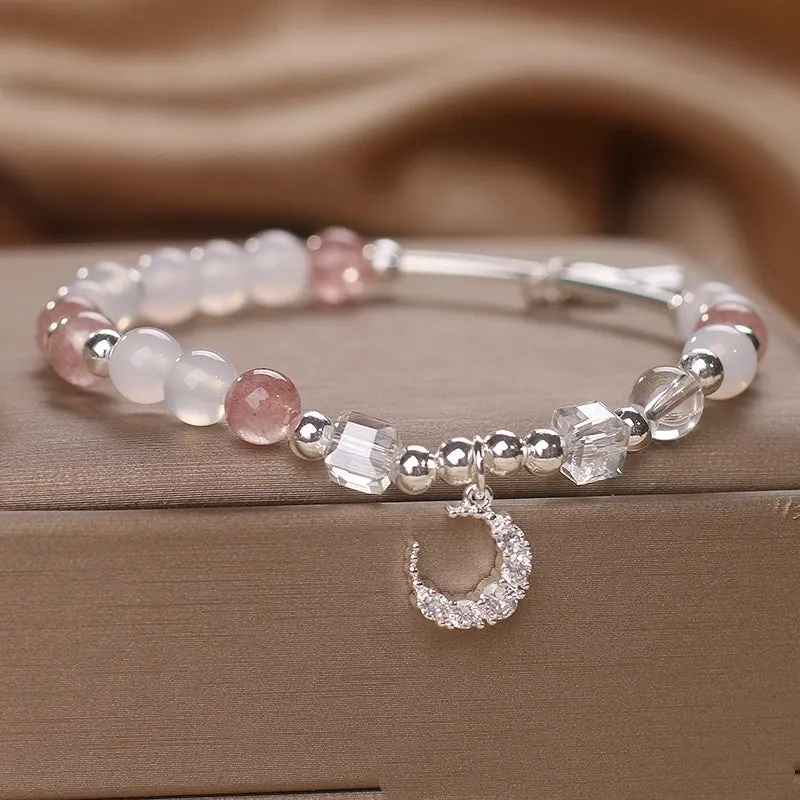 Natural strawberry quartz bracelet with pink cube sugar beads and moon pendant on a flat surface