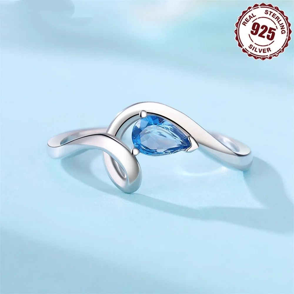 S925 sterling silver open-end ring with curve inlaid blue zircon stone and fold design on a white background