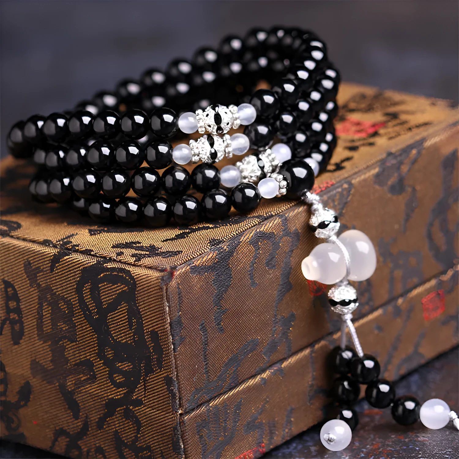 Natural black agate bracelet with 108 beads showing geometric shapes and numeric design elements
