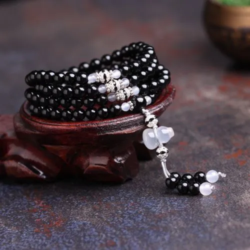 Natural black agate bracelet with 108 beads showing geometric shapes and numeric design elements