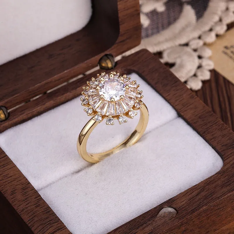 Gold electroplated copper flower ring with open mouth design on a plain background