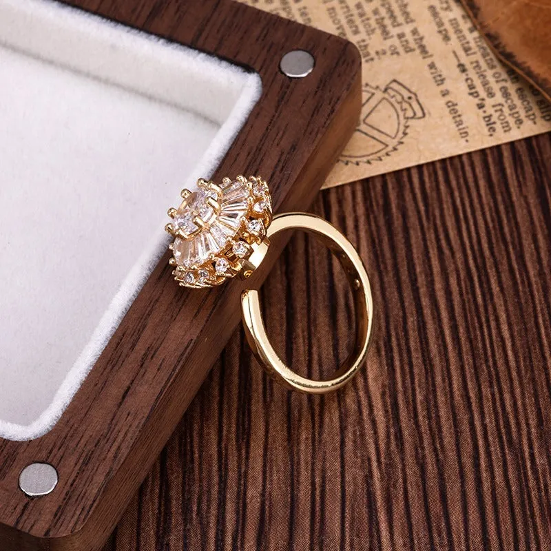 Gold electroplated copper flower ring with open mouth design on a plain background