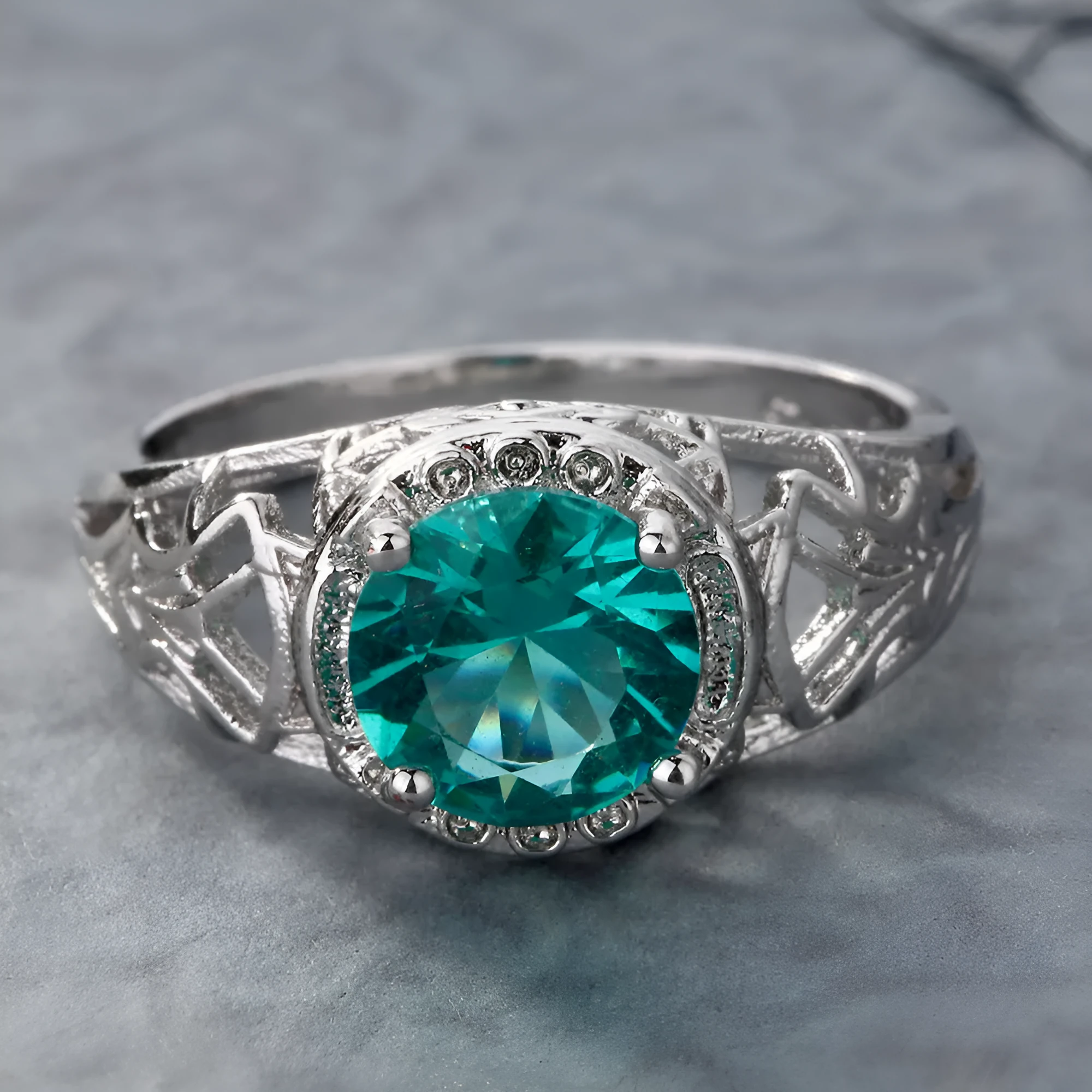 Silver electroplated copper ring with inlaid zircon stone on neutral background