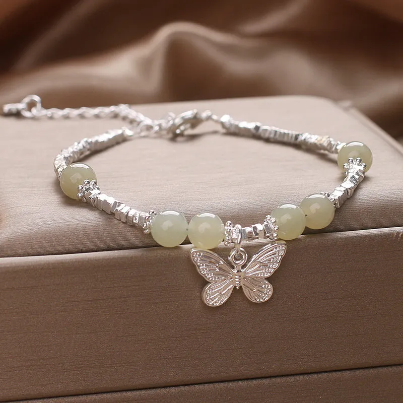 Hetian jade beads bracelet with silver butterfly pendant on a white background