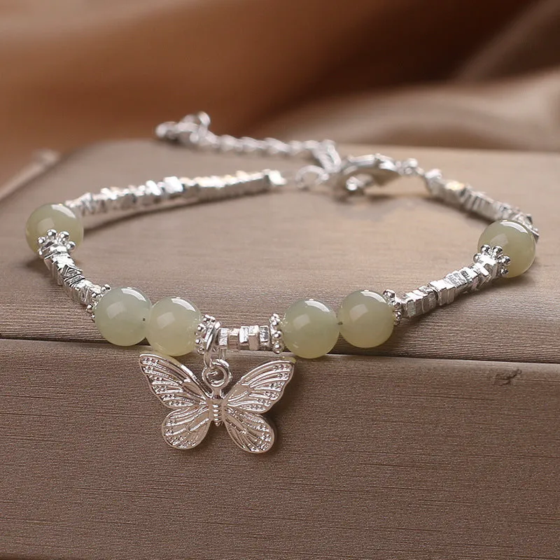 Hetian jade beads bracelet with silver butterfly pendant on a white background