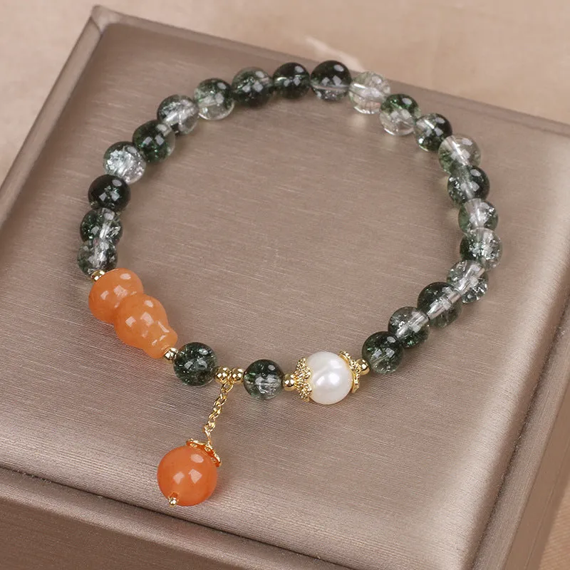 Green phantom quartz crystal bracelet with pearl and rhinestone accents on a white background, 17cm women's size