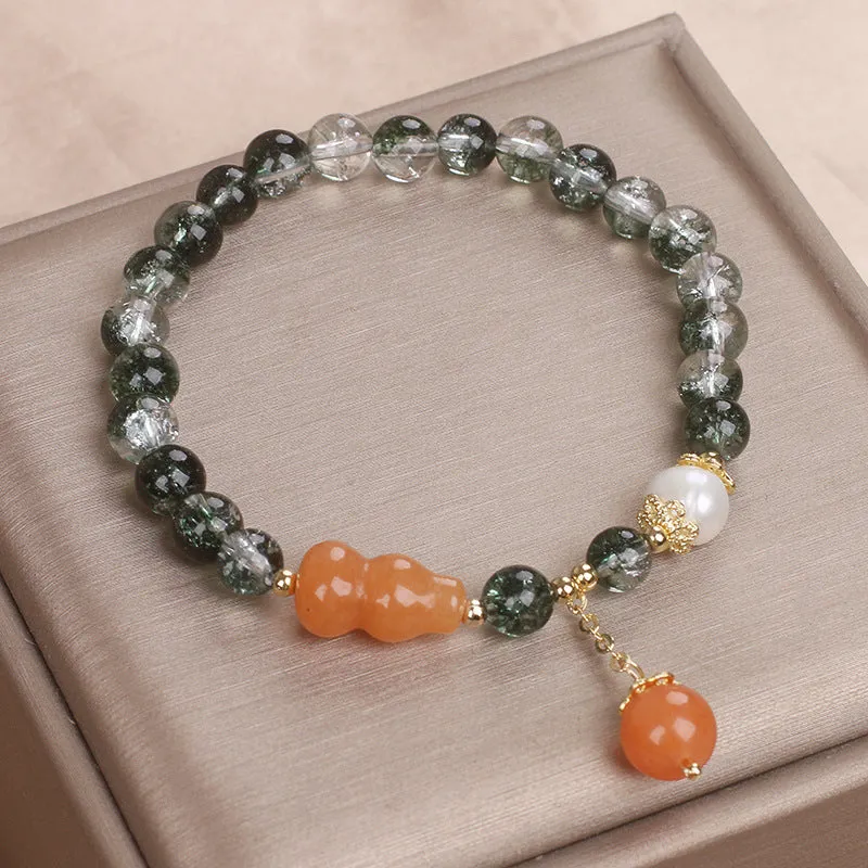 Green phantom quartz crystal bracelet with pearl and rhinestone accents on a white background, 17cm women's size