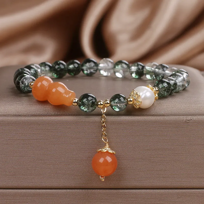 Green phantom quartz crystal bracelet with pearl and rhinestone accents on a white background, 17cm women's size