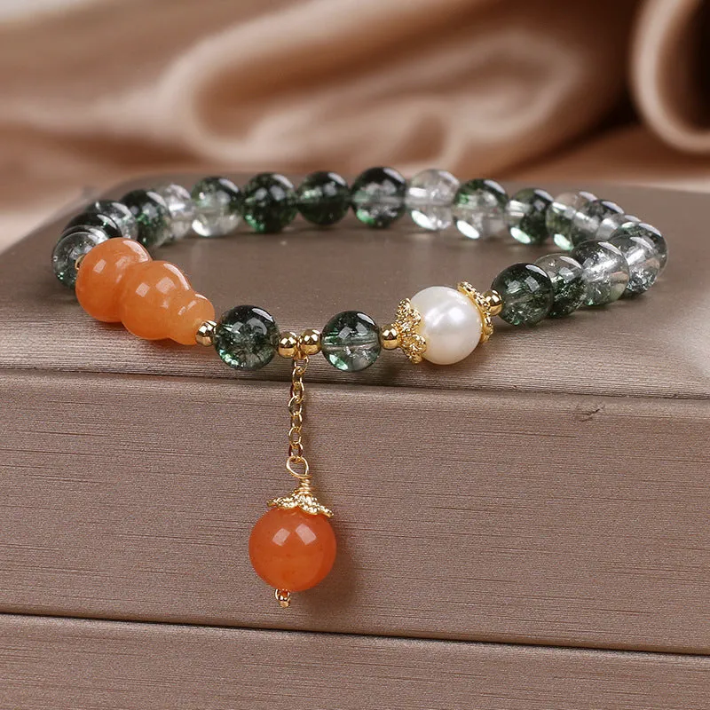 Green phantom quartz crystal bracelet with pearl and rhinestone accents on a white background, 17cm women's size
