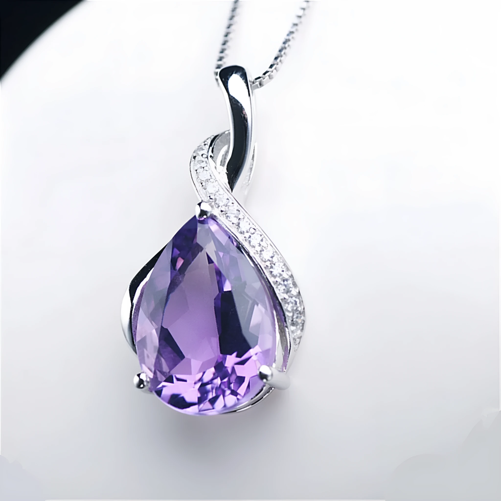Copper drop shape pendant necklace with electroplated finish on a dark blue diamond square chain