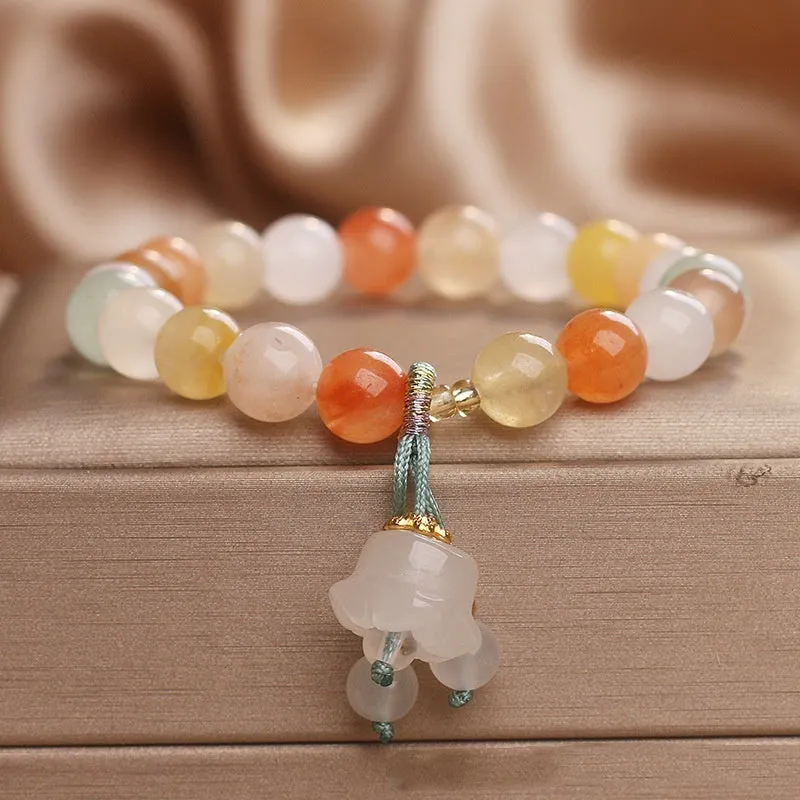 Natural Jinsi Jade round bead beaded bracelet with lily pendant on neutral background