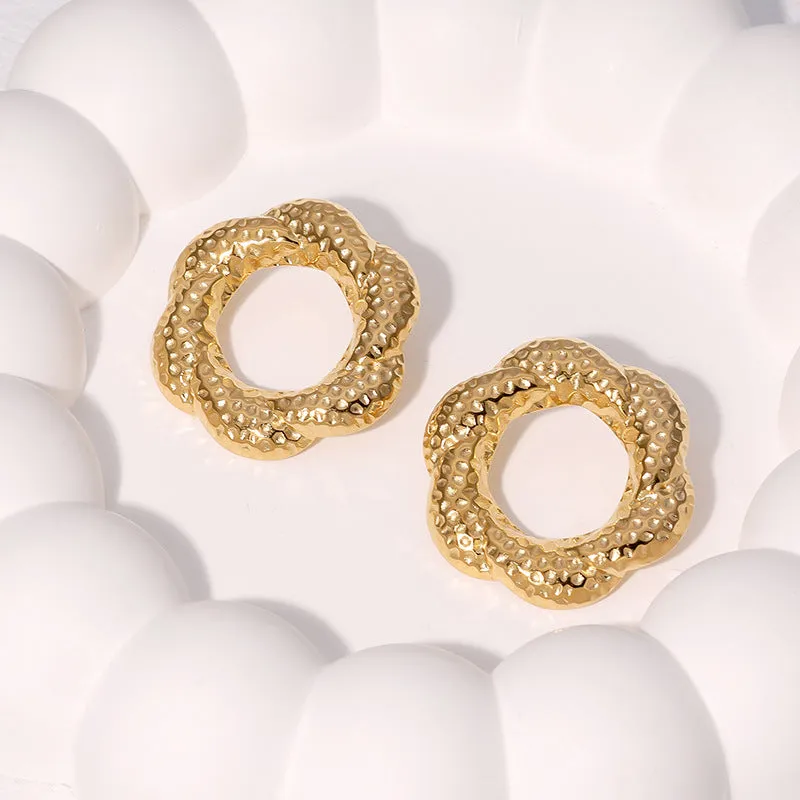 Stainless steel round stud earrings in gold and steel colours on a neutral background