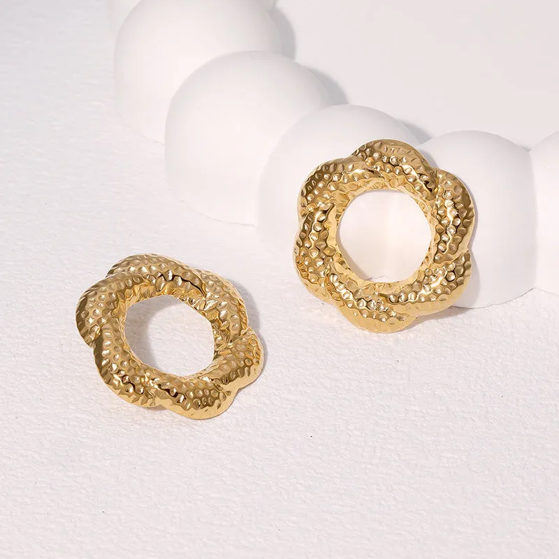 Stainless steel round stud earrings in gold and steel colours on a neutral background