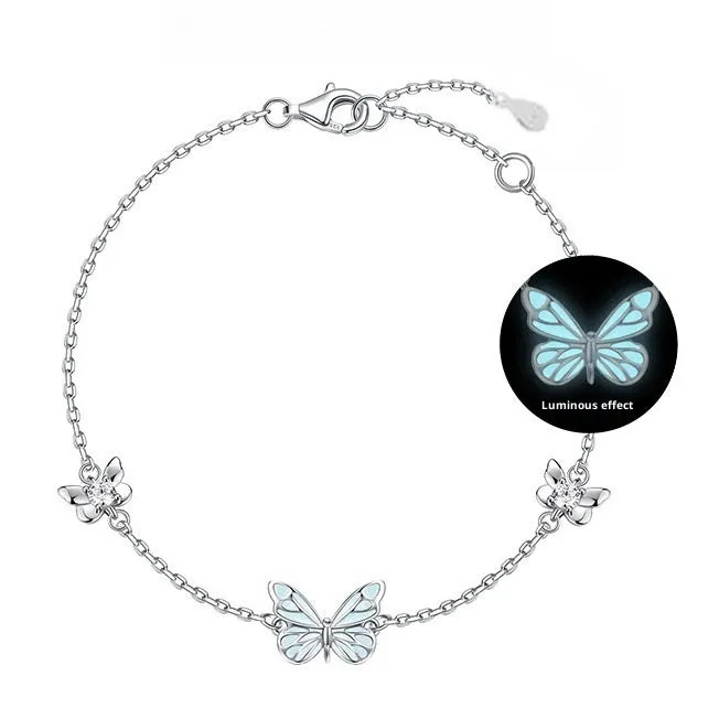 Set of 925 silver luminous butterfly bracelet necklace and earrings with floral petals on white background