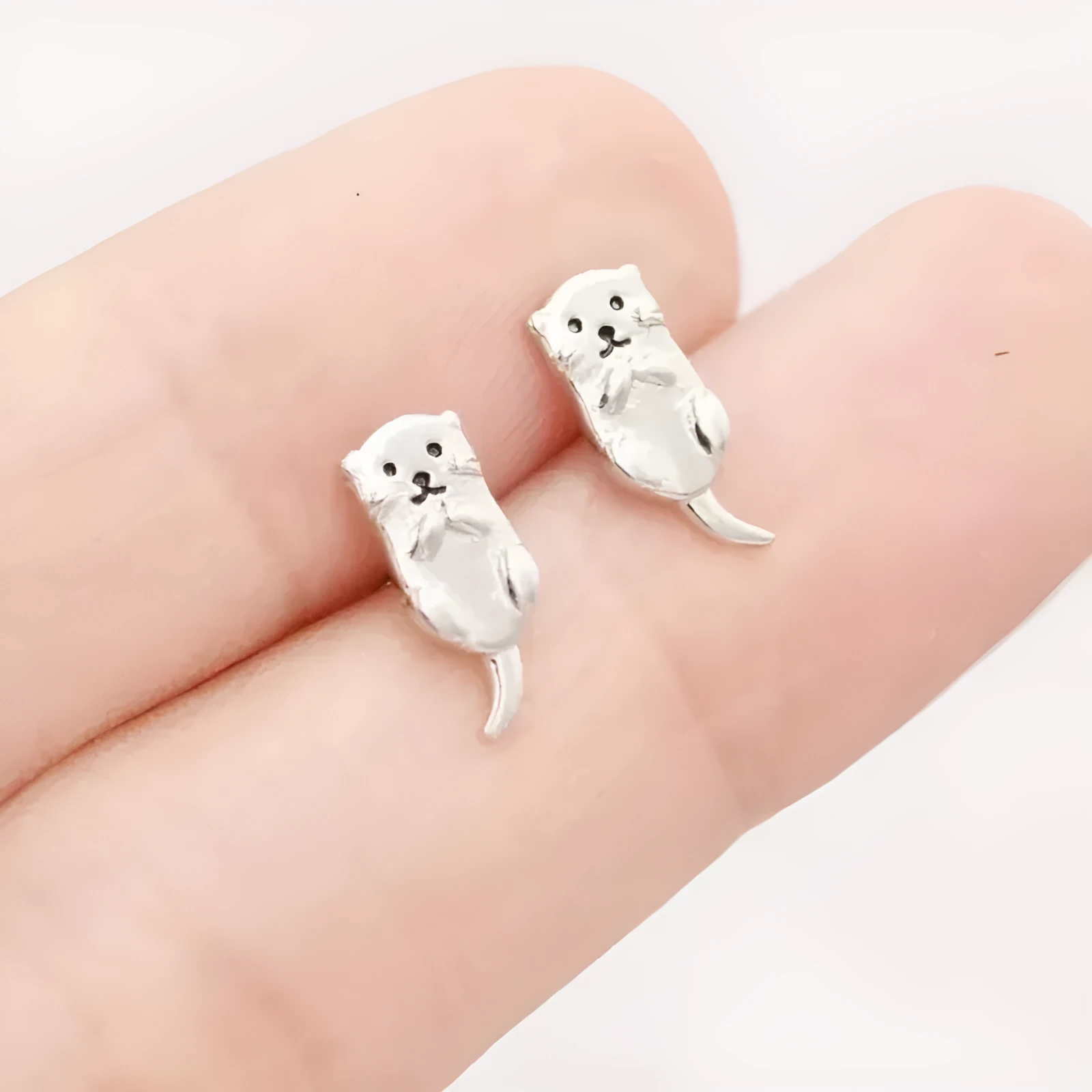 Simple compact three-dimensional animal-shaped copper earrings with electroplated finish in white gold colour