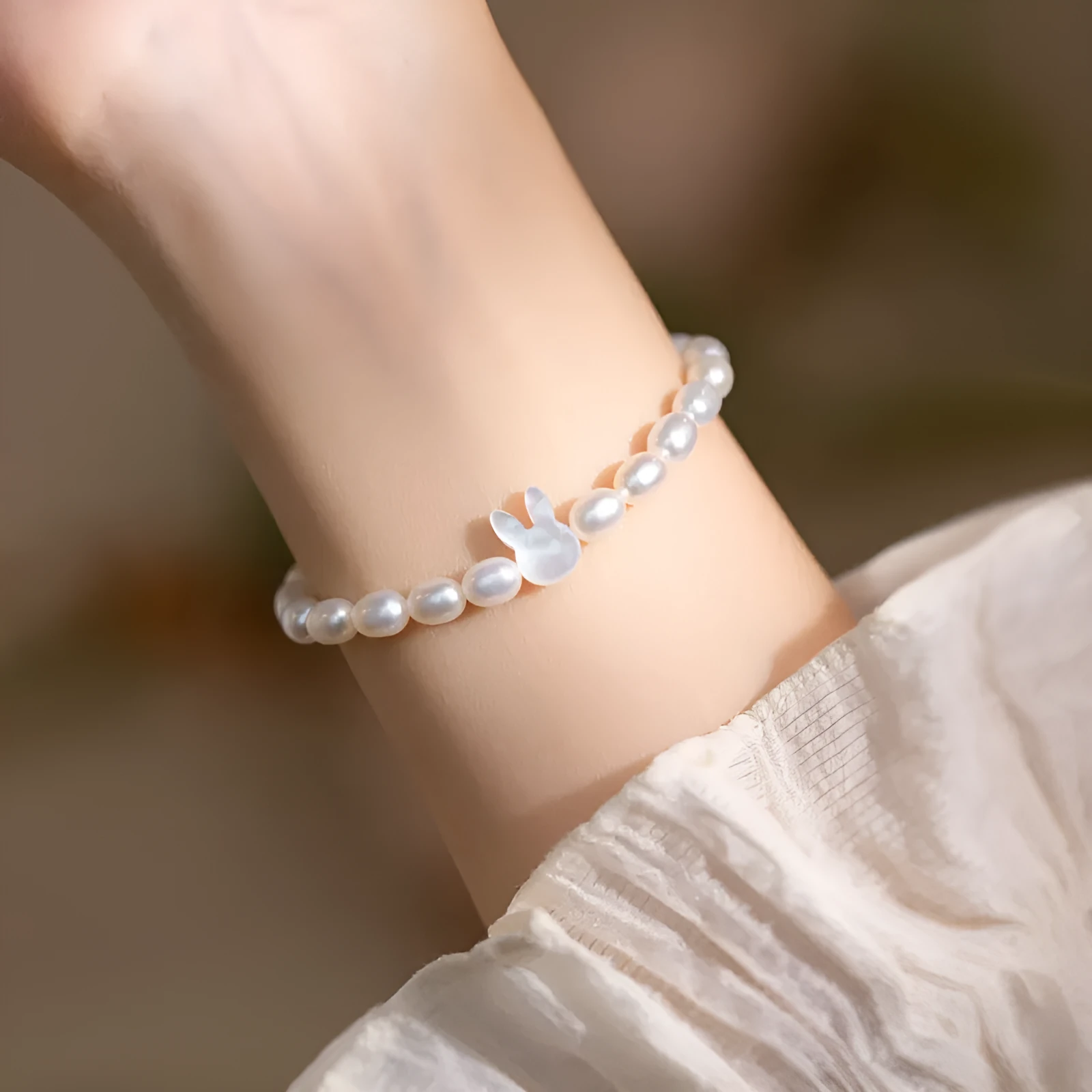 White pearl and 925 silver rabbit charm bracelet on a 16cm elastic string.