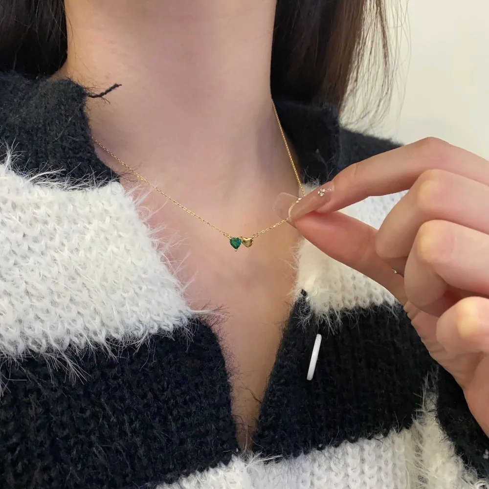 925 silver heart necklace with emerald zircon in gold finish on display