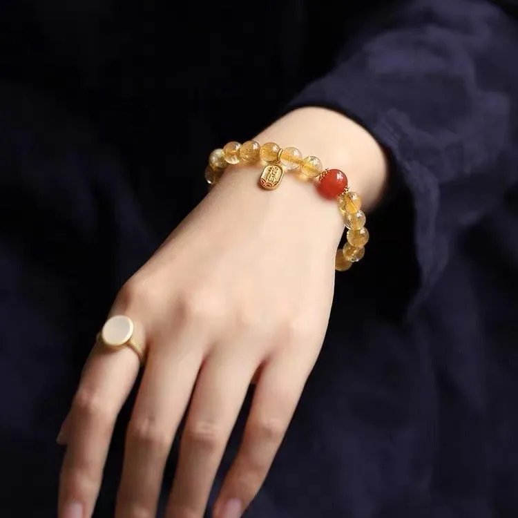 Polished natural red agate lucky beads bracelet on a wrist, showing ruby colour beads.