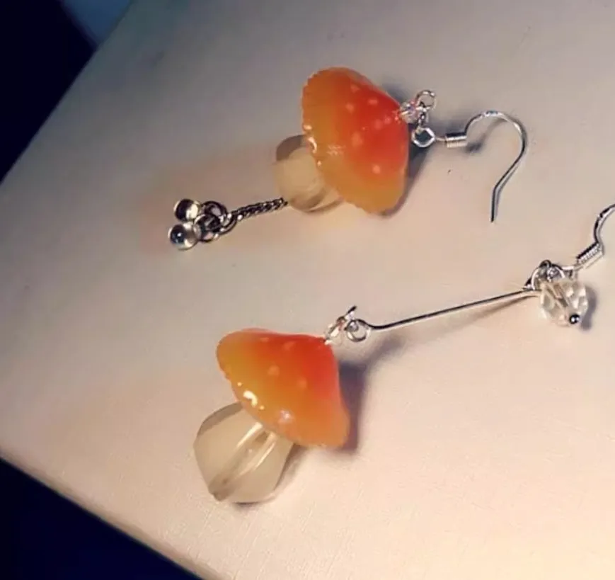 Resin heat shrinkable small mushroom earrings in yellow original style on plain background