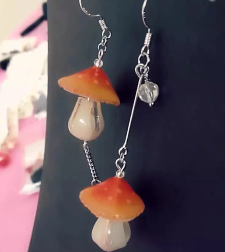 Resin heat shrinkable small mushroom earrings in yellow original style on plain background