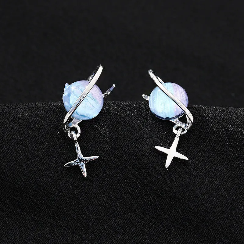 Metal geometric planet earrings in multicolour finish on a neutral background