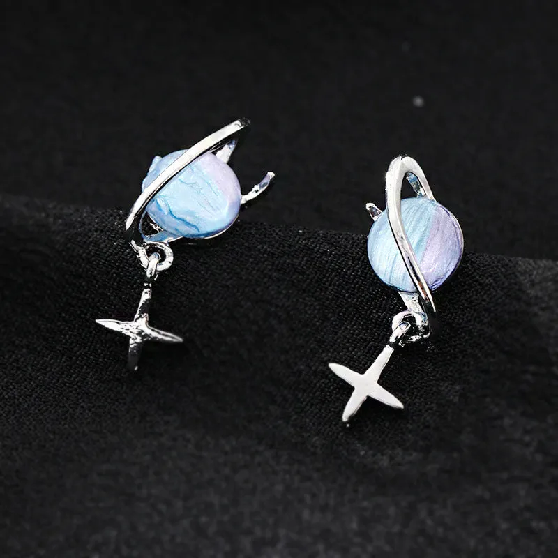 Metal geometric planet earrings in multicolour finish on a neutral background