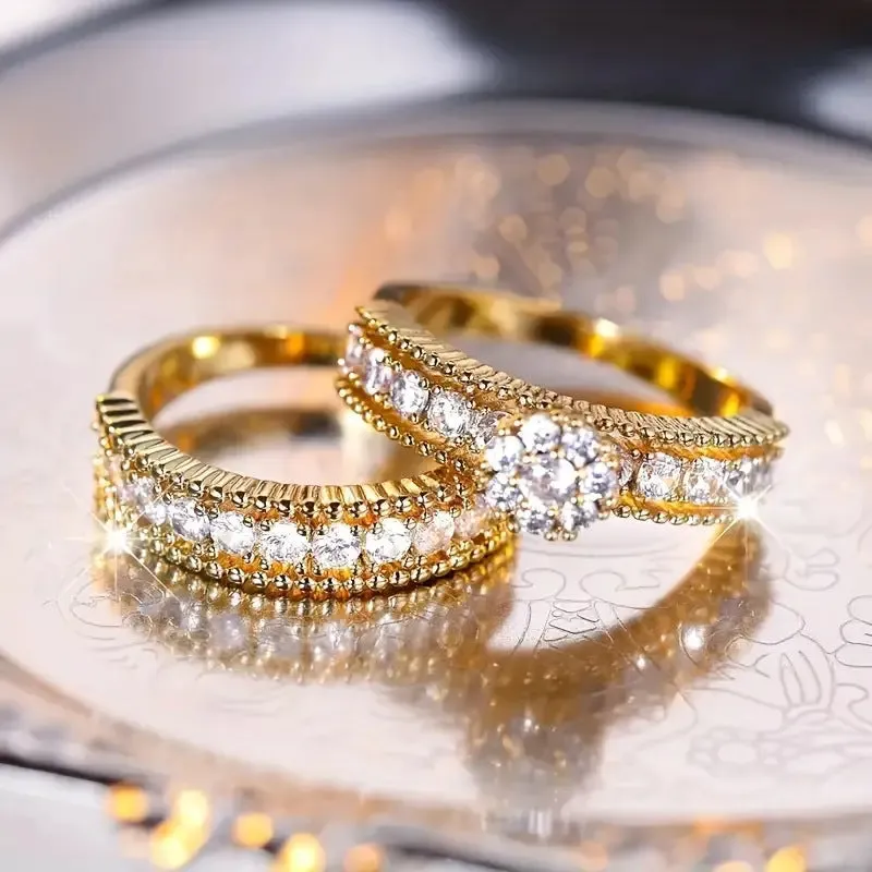 Two gold geometric zinc alloy rings with electroplated finish on white background