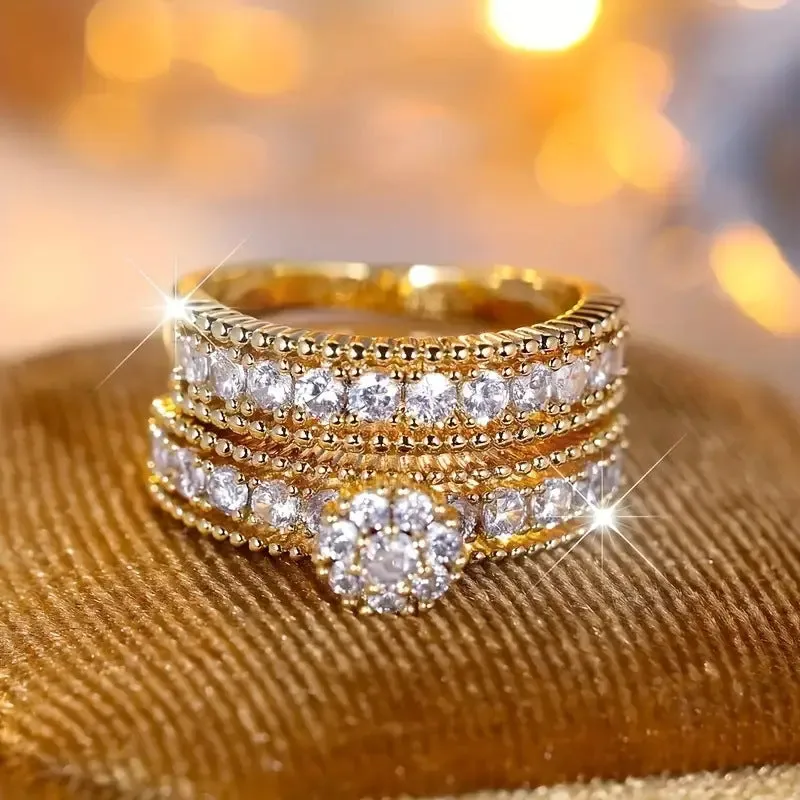 Two gold geometric zinc alloy rings with electroplated finish on white background
