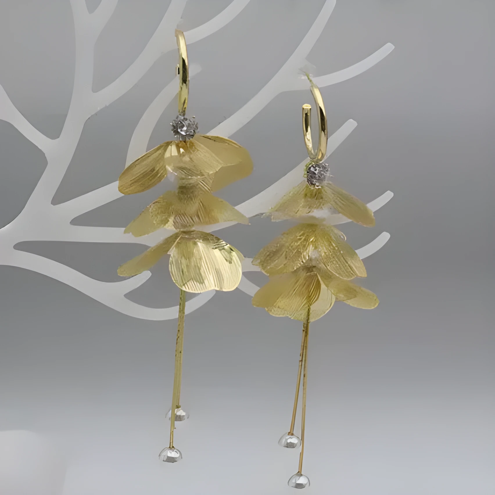 Gold floral petal pearl fringe drop earrings with electroplated alloy finish on neutral background