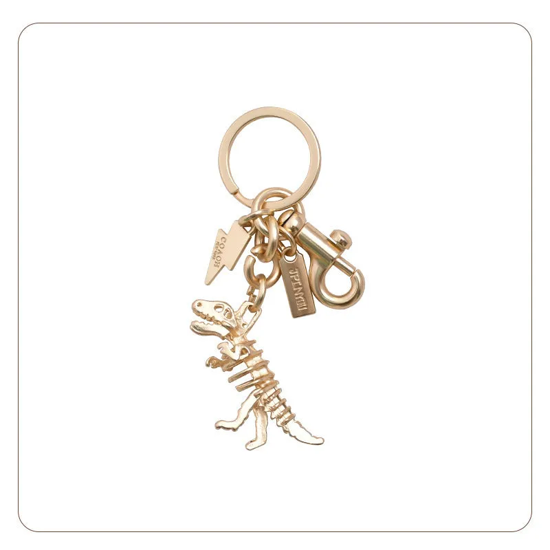 Zinc alloy dinosaur keychain with golden bone dragon pattern on grey background