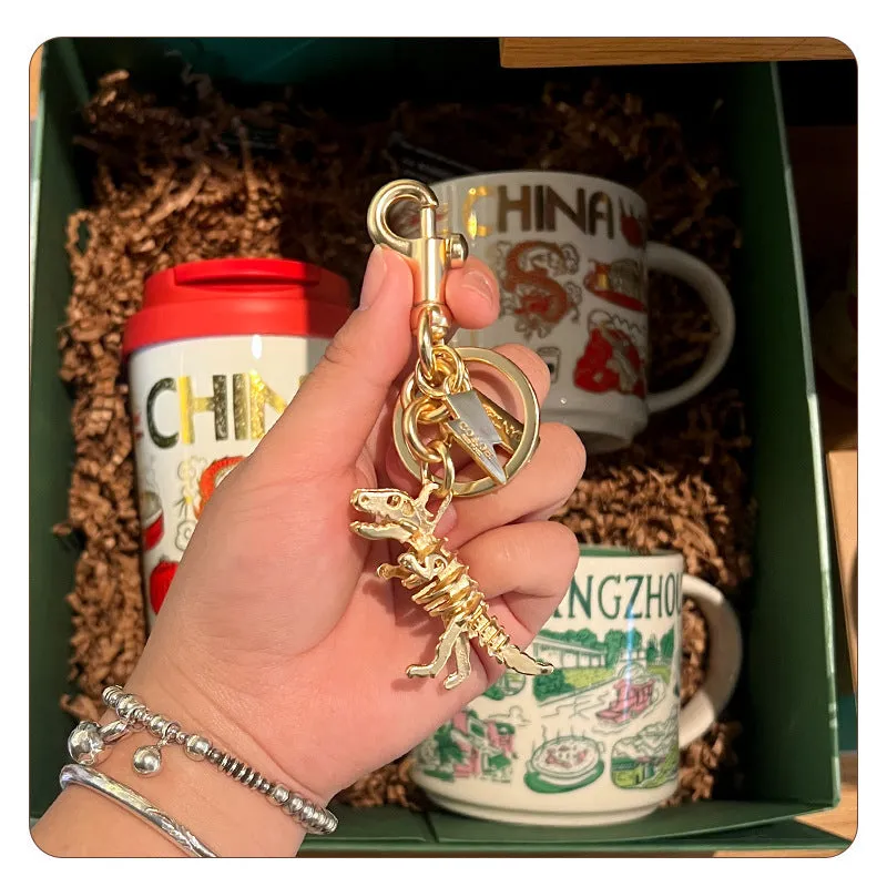 Zinc alloy dinosaur keychain with golden bone dragon pattern on grey background