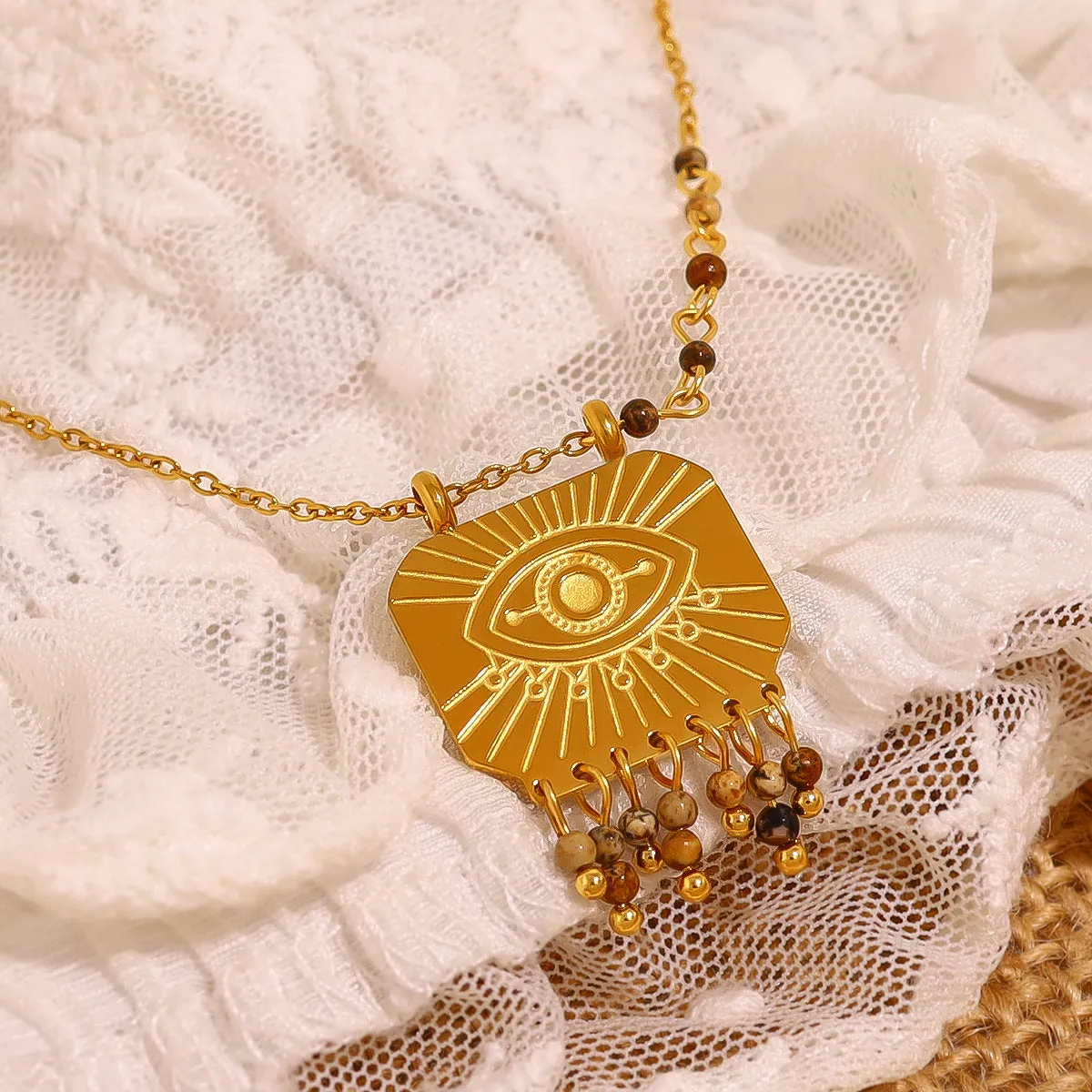 Retro gold titanium steel chain necklace with square natural stone pendant and evil eye motif on white background