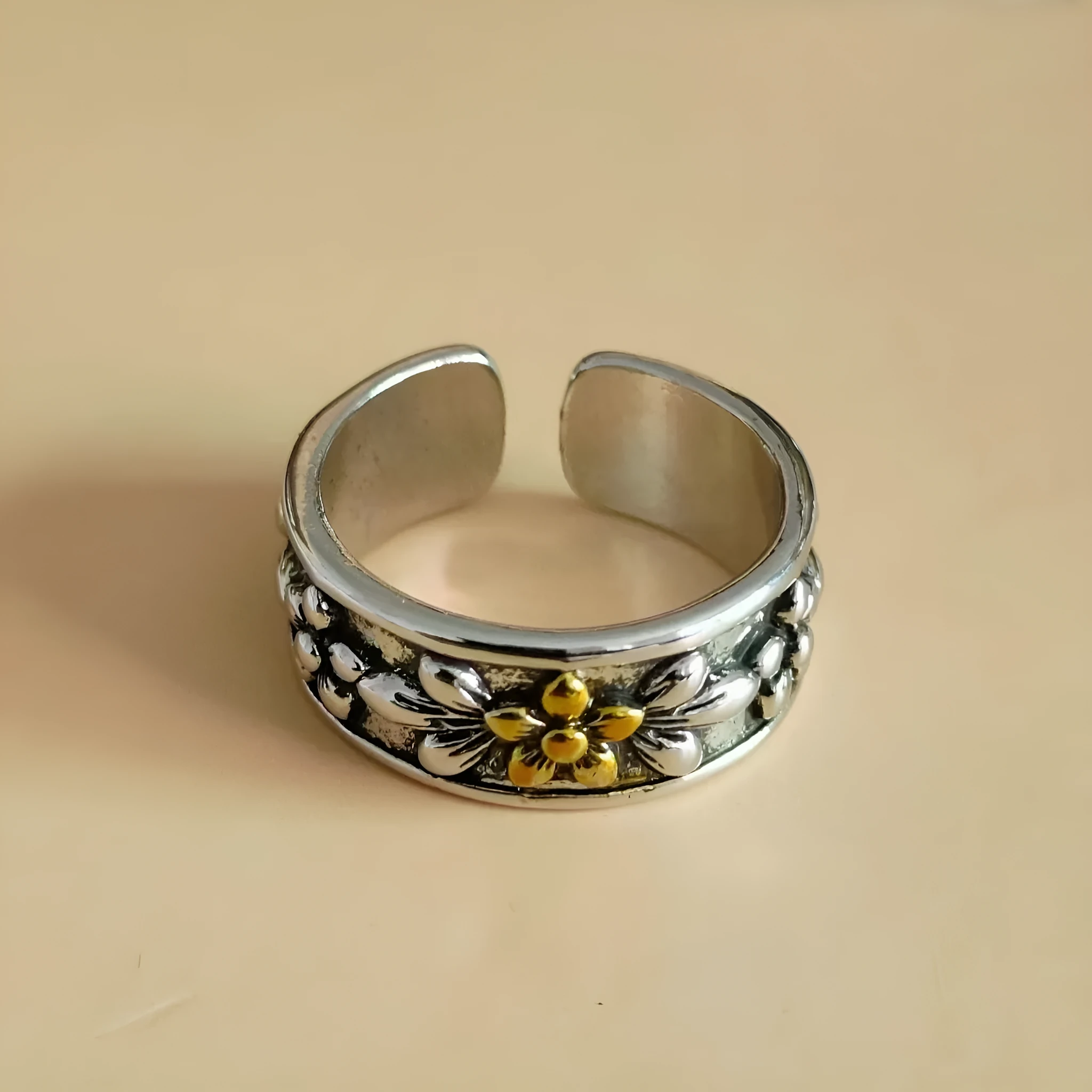 Vintage antique silver gold flower open ring with camellia floral design on a neutral background