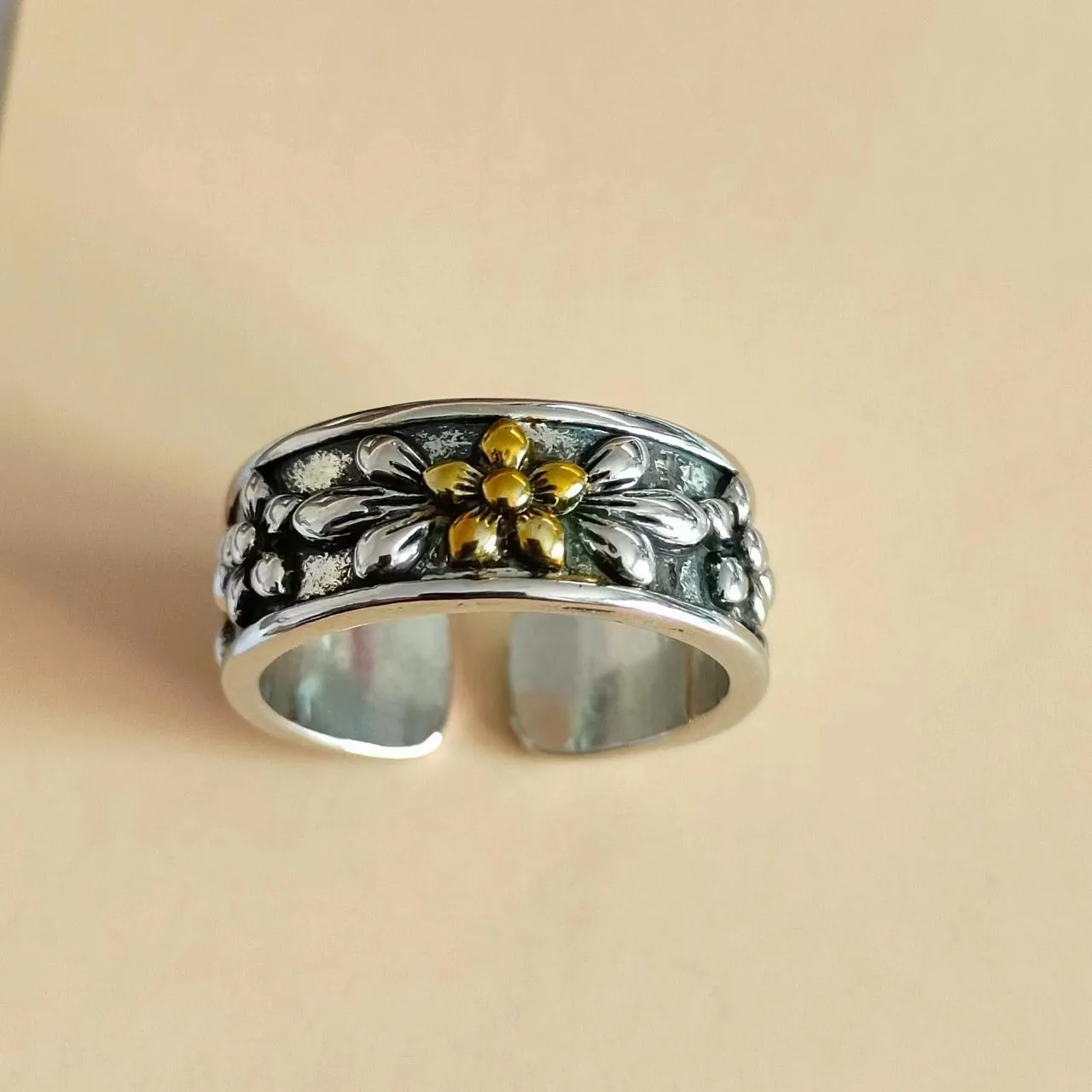 Vintage antique silver gold flower open ring with camellia floral design on a neutral background