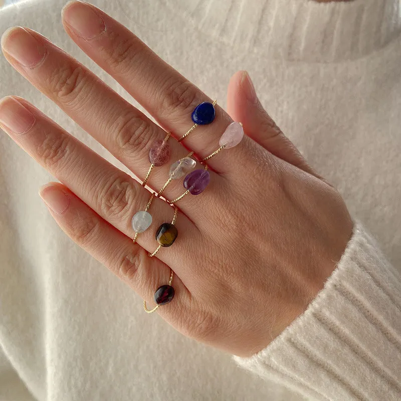 Geometric silver-tone ring with a coloured agate stone in a niche design, side view.