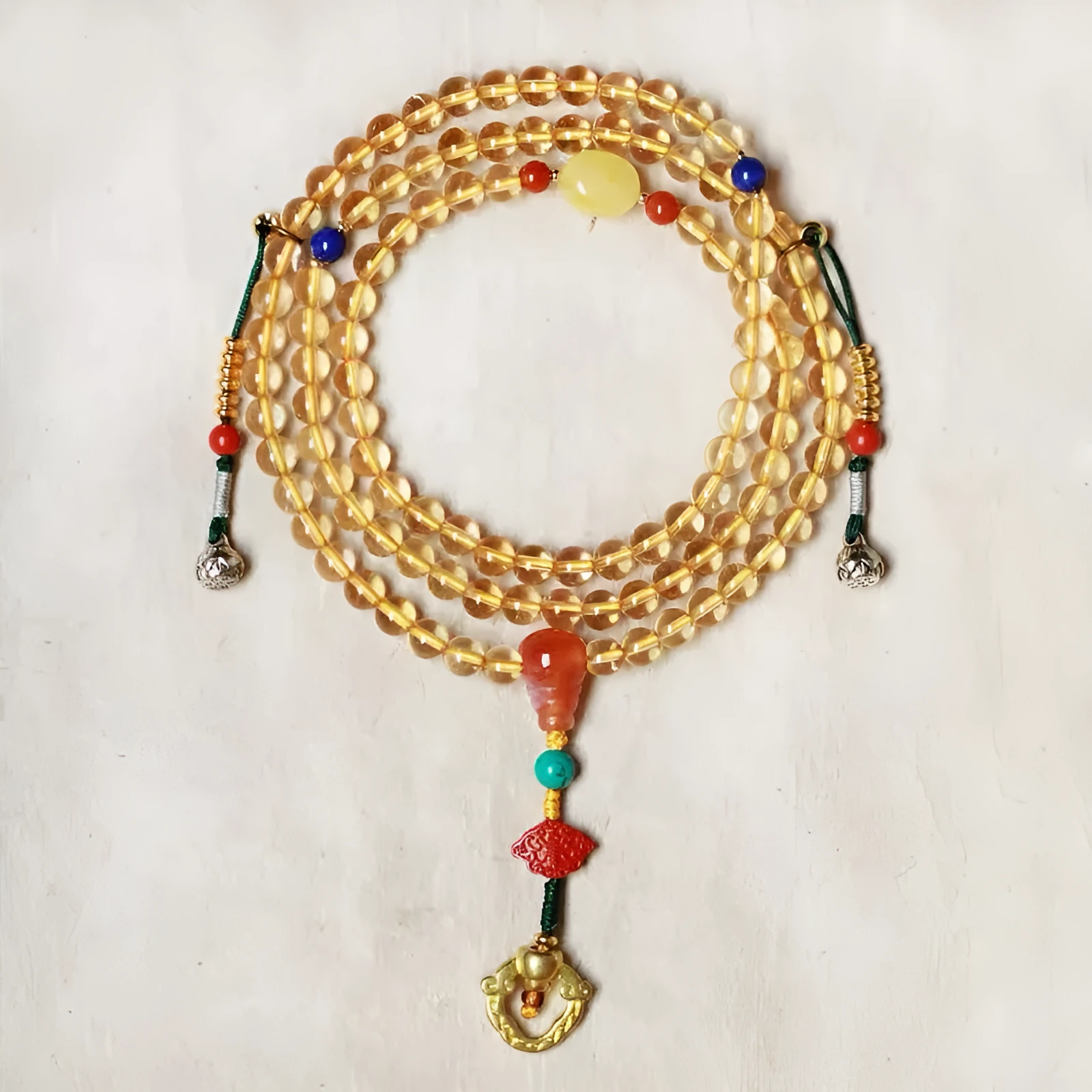 Close-up of a yellow Brazilian citrine bracelet with small 1mm beads on a black filament cord.