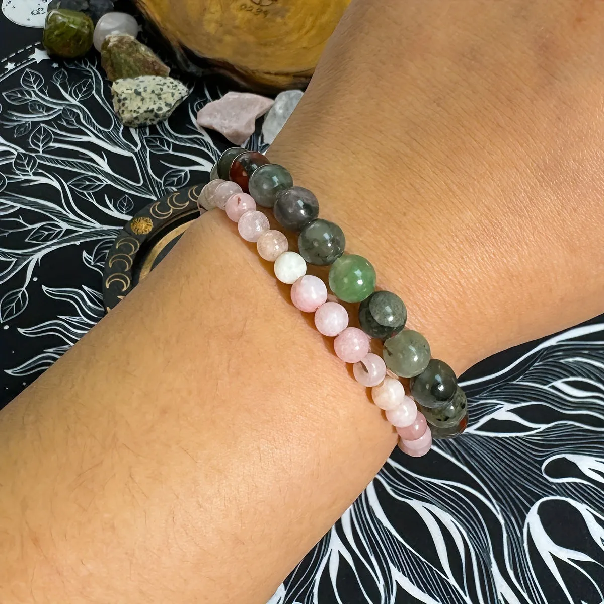 Handmade African Bloodstone beaded bracelet with 8mm transparent glass beads on neutral background