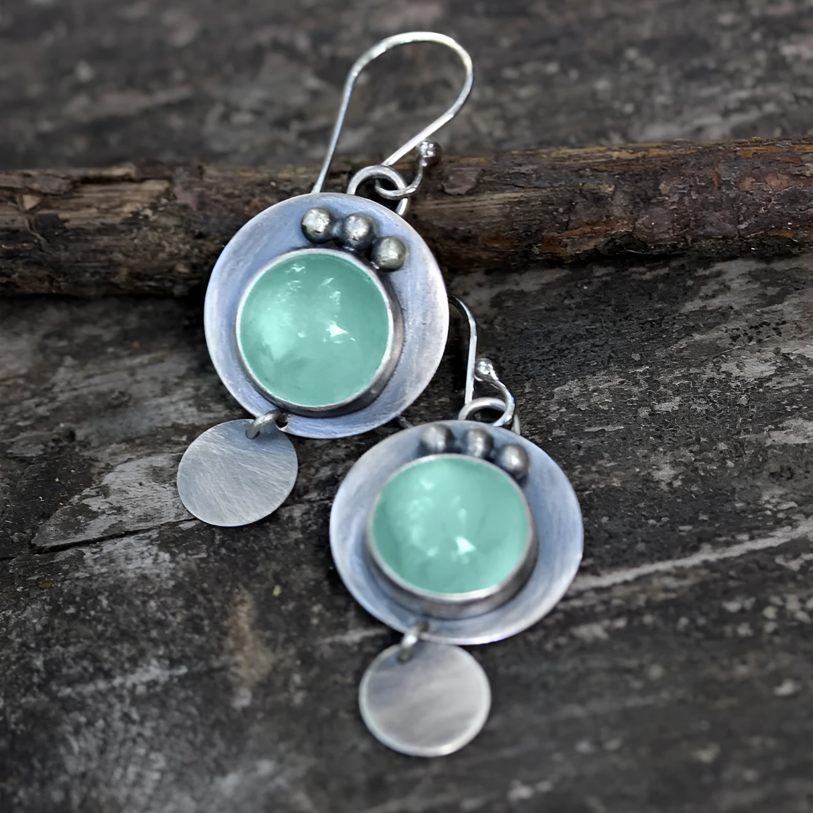 Silver geometric round mint turquoise earrings for women on simple background.